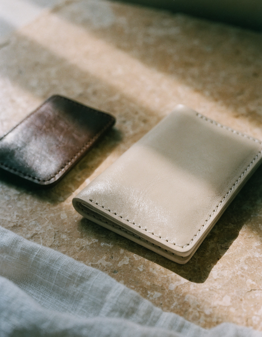 Slim leather wallet and card case on a warm stone surface — Vessa Bags Wallets & Accessories collection